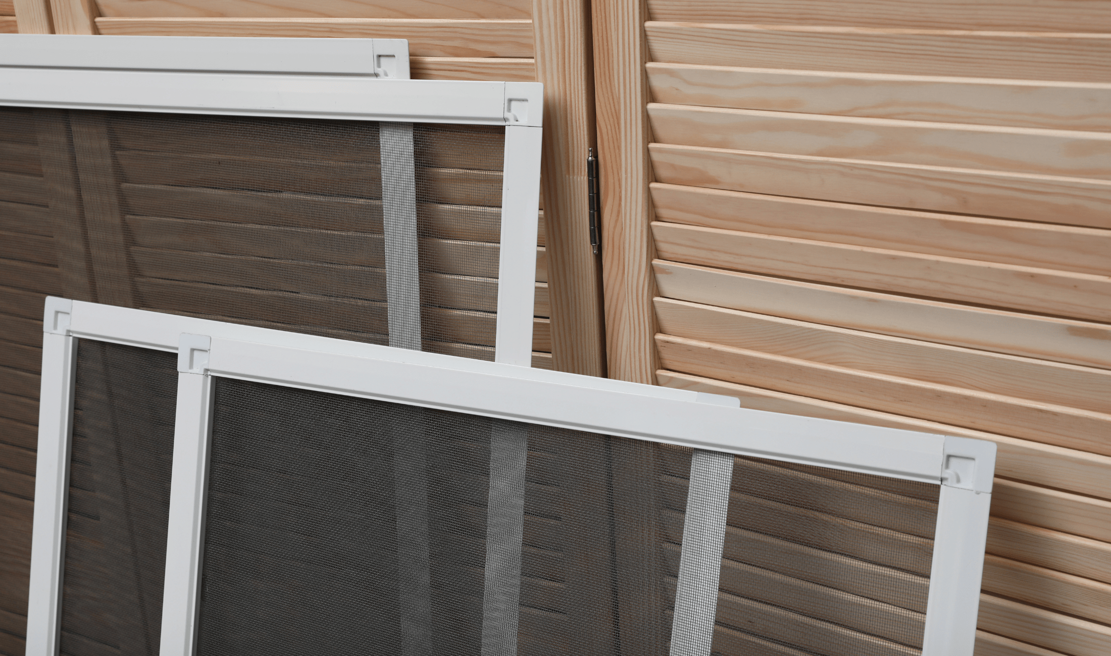 Multiple window screens leaning against a wall.